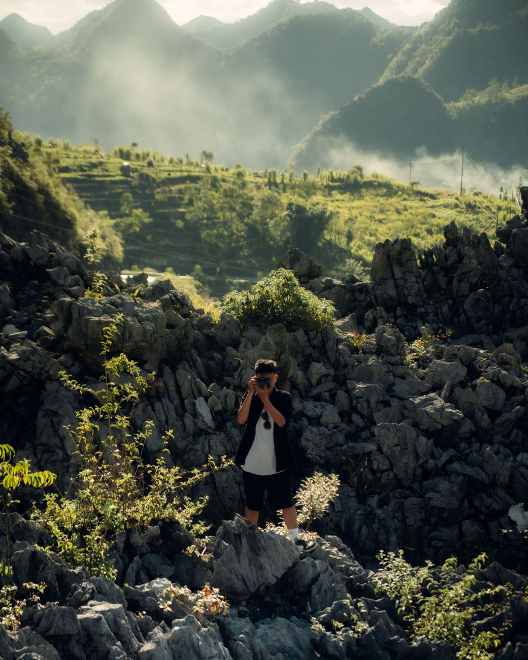Travel photographer looking out over quiet misty mountain valley