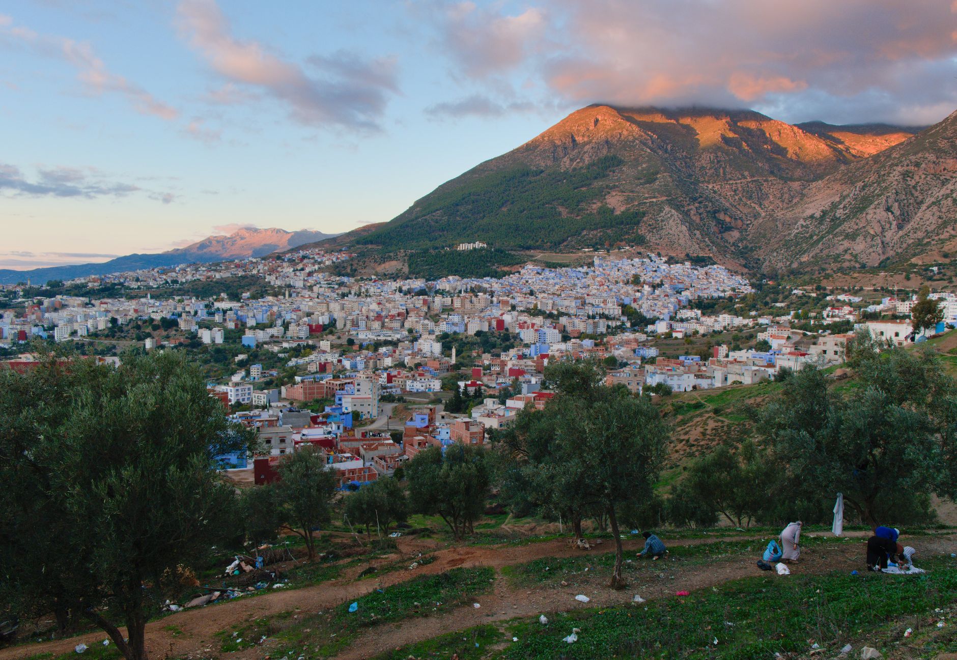 Earthen riad rooftop and sweeping view of the Atlas Mountains at dusk